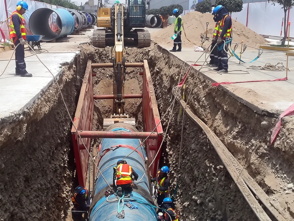 Trabajadores realizando excavaciones y reubicación de interferencias con tuberías en la vía Panamericana, Lima.